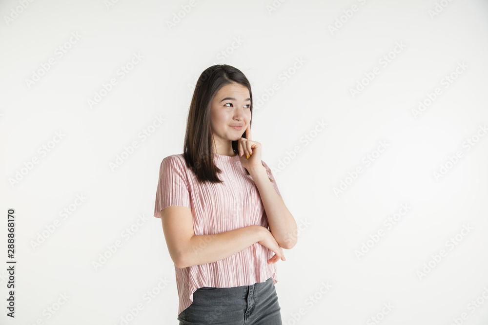 Beautiful female half-length portrait isolated on white studio background. Young emotional woman in casual clothes. Human emotions, facial expression concept. Thinks or dreams, looks thoughtful. Beautiful female half-length portrait isolated on white studio background. Young emotional woman in casual clothes. Human emotions, facial expression concept. Thinks or dreams, looks thoughtful.