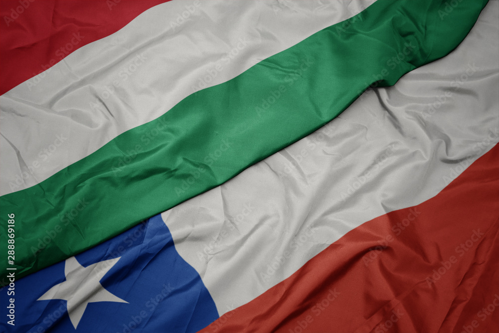 waving colorful flag of chile and national flag of hungary.