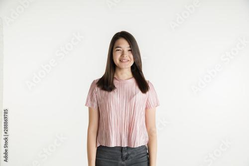 Beautiful female half-length portrait isolated on white studio background. Young emotional woman in casual clothes. Human emotions, facial expression concept. Smiling, looks confident.