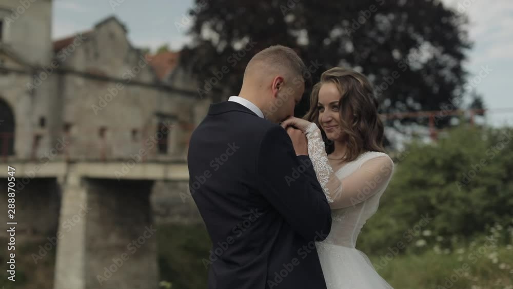 Caucasian groom with bride near old castle. Wedding couple. Happy newlyweds Caucasian groom with bride near old castle. Wedding couple. Happy newlyweds
