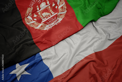 waving colorful flag of chile and national flag of afghanistan.