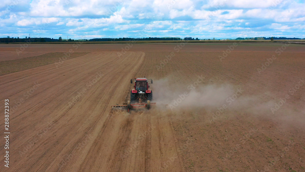 Obraz premium Aerial view drone of harvest field with tractor mows dry grass. Autumn yellow field with a haystack after harvest top view. Harves. Ting in the fields. Stock up