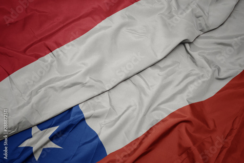 waving colorful flag of chile and national flag of indonesia.