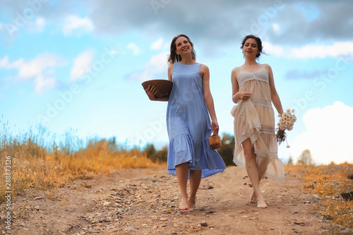 Two girls in dresses in autumn field