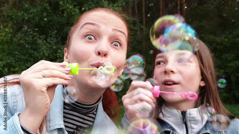 a young woman with her daughter blowing bubbles in the Park on a summer evening, mother's day . Family relation a young woman with her daughter blowing bubbles in the Park on a summer evening, mother's day . Family relation