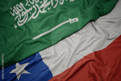 waving colorful flag of chile and national flag of saudi arabia.