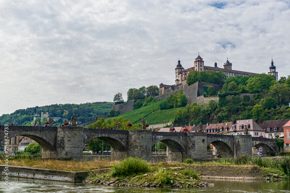 View of the Marienberg fortress and the old city bridge from the banks of the River Meno. Photography taken in Würzburg, Bavaria, Germany.