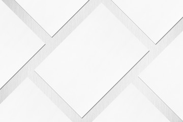 Close up of empty white rectangle poster or card mockups lying diagonally with soft shadow on neutral light grey textured background. Flat lay, top view. Open composition.
