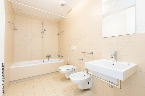 Bath with modern beige tiles  new sanitary fixtures