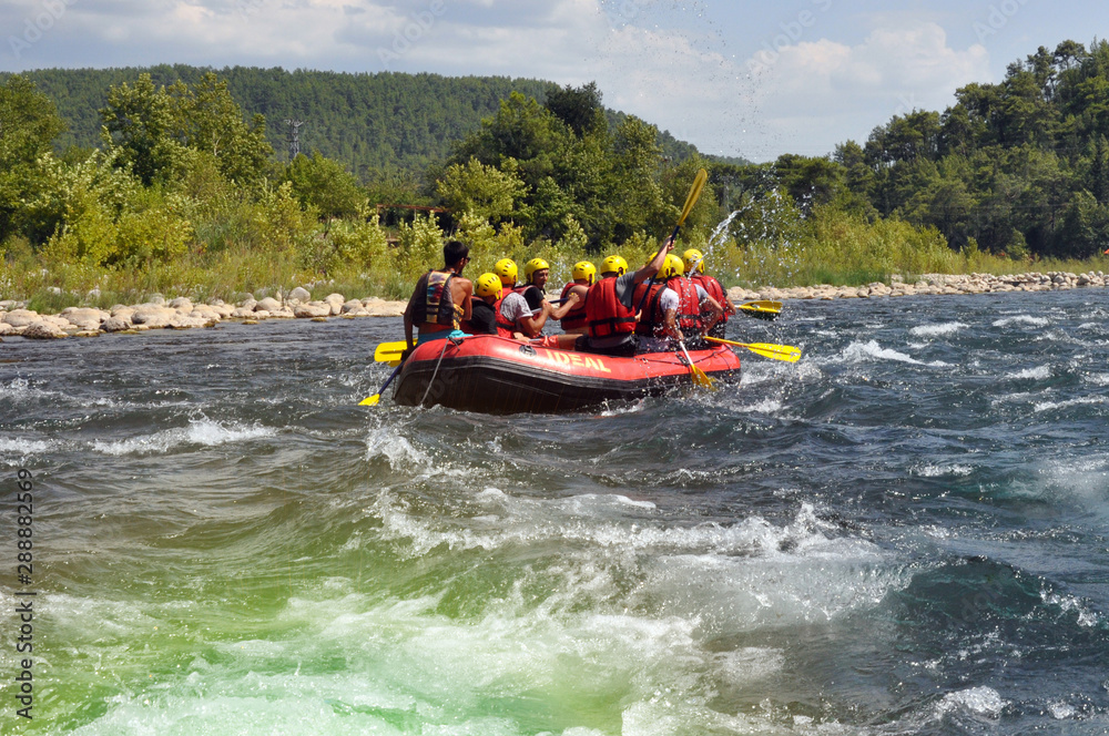 Rafting, a group of young people with a guide rafting along a mountain river. Extreme and fun sport at a tourist attraction.