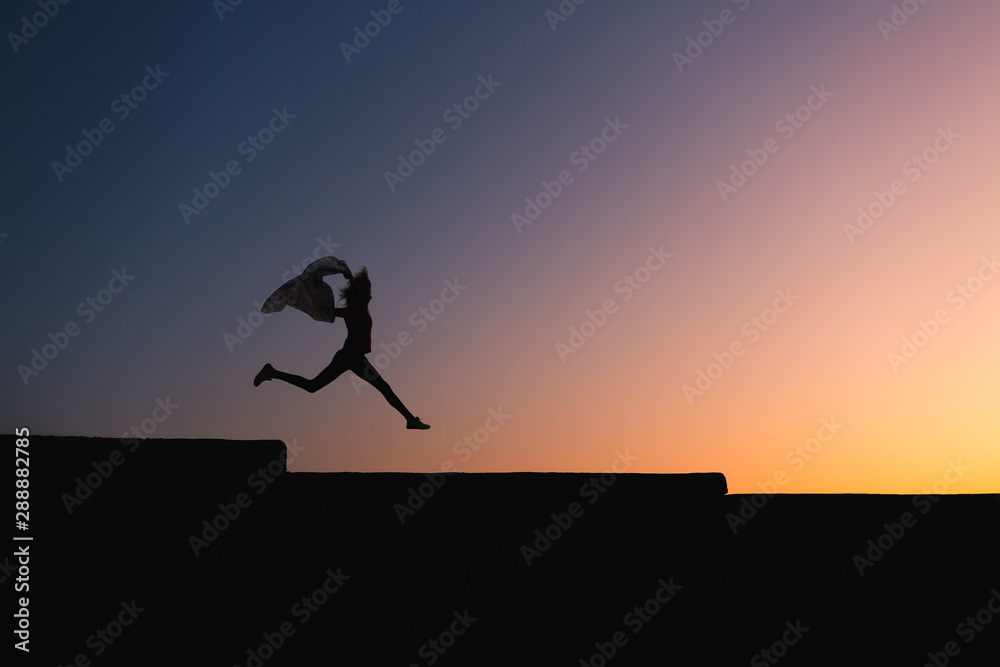 Silhouette of slim body woman jumping high