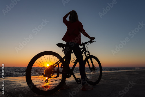 woman on bike enjoying the sunrise