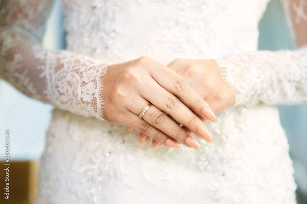 Close up hands with engagement diamond ring on finger of bride in white gown or wedding dress.Elegant woman diamond ring on finger of bride in wedding ceremony. Close up hands with engagement diamond ring on finger of bride in white gown or wedding dress.Elegant woman diamond ring on finger of bride in wedding ceremony.