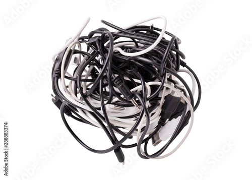 A coil of various wires for gadgets on a white background. Black and white wires tangled together. Tangle of tangled wires usb and micro usb, audio cable jack.