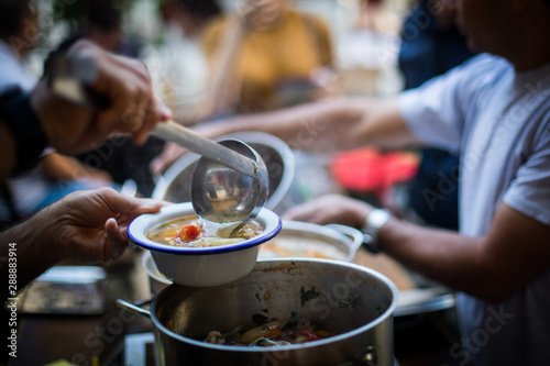 Person serving a portion of fish soup