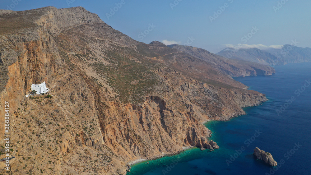 Aerial drone photo of breathtaking whitewashed holy Monastery of Panagia Hozoviotissa built in a steep cliff overlooking the Aegean deep blue sea, Amorgos island, Cyclades, Greece