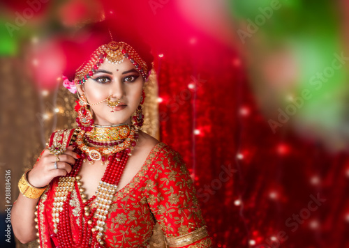 Portrait of an Indian bride wearing traditional red lehanga with gold jewelry an Fototapeta
