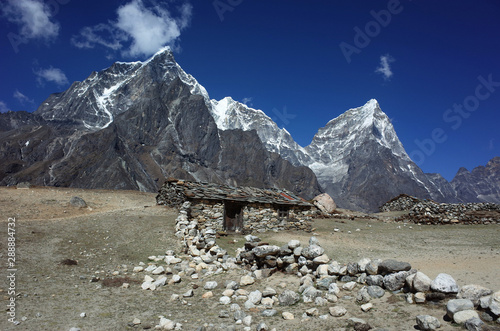 Old stone house in Dusa village (4530 m), Everest trek, View of Tabuche peak (6367 m), Cholatse (6335 m) and Arakam Tse (6423 m) in Himalayas mountains, Sagarmatha national park, Solukhumbu, Nepal photo