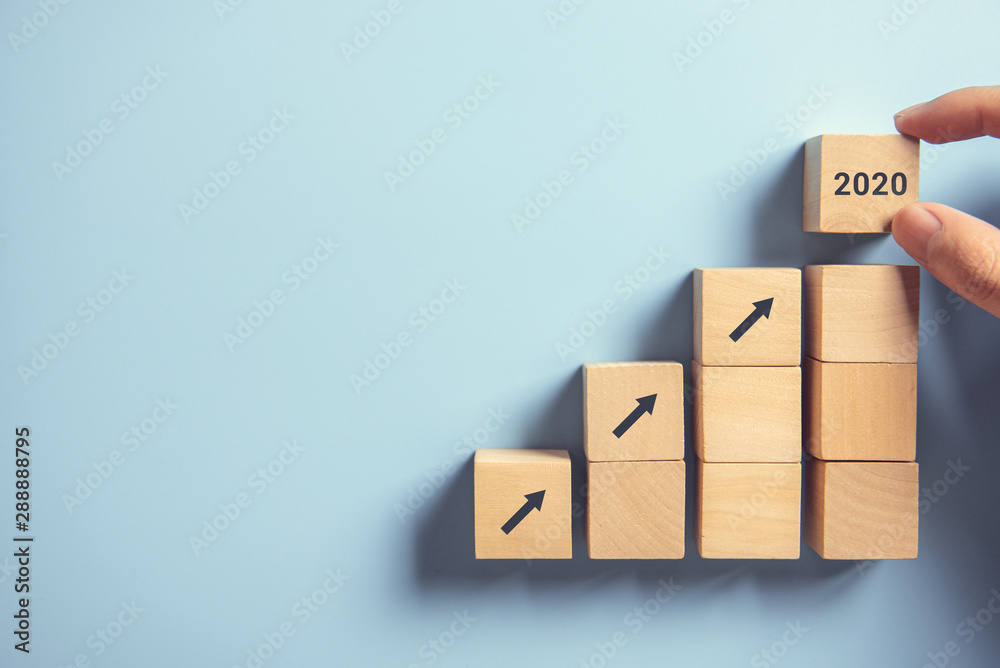 Business concept growth 2020 success process, Close up Woman hand arranging wood block stacking as step stair on paper blue background, copy space. - obrazy, fototapety, plakaty 