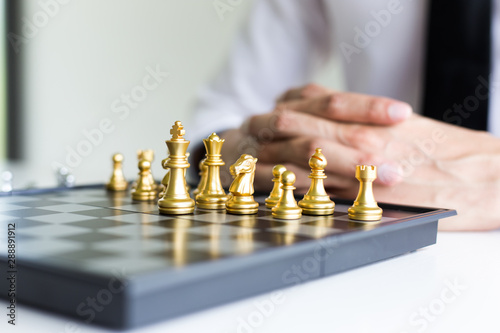 A young business man is playing chess, business strategy to be successful
