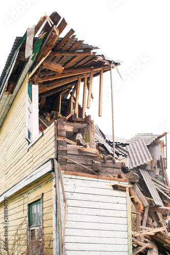 Destruction of an old wooden abandoned house. Demolition of the house