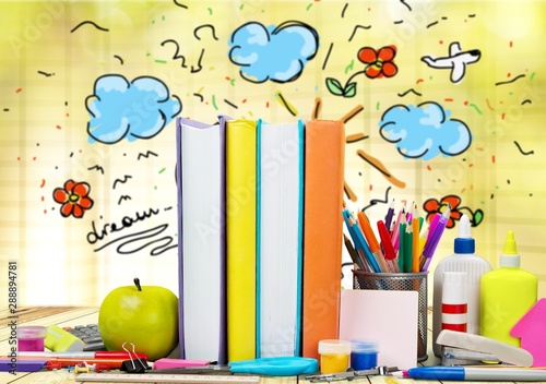 School supplies - books, pencils and apples isolated on blurred background