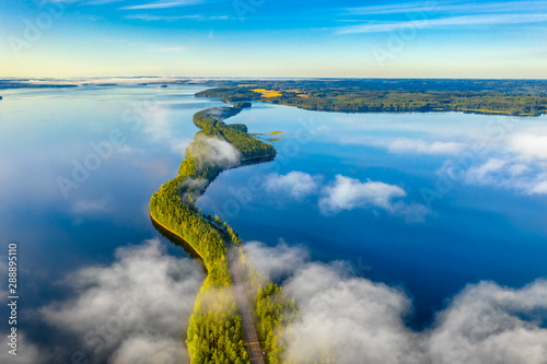 Aerial view of Pulkkilanharju Ridge, Paijanne National Park, southern part of Lake Paijanne. Landscape with drone. Fog, Blue lakes, fields and green forests from above on a sunny summer morning.