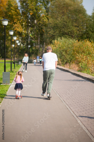 Father and daughter on scooters