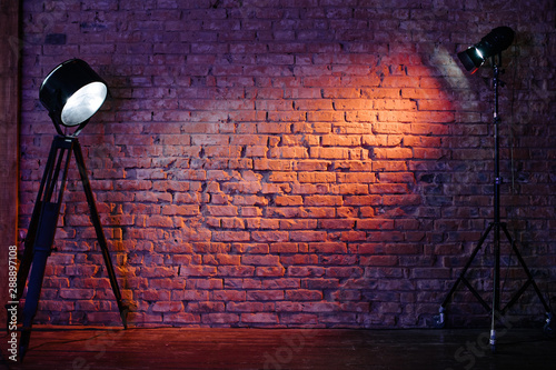 Old retro red brick wall being lit by a stage light bulb light. Constant light modifier projecting light on it photo