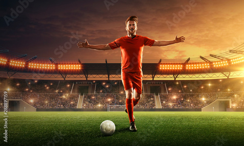 Soccer player on a crowded stadium with cheering fans celebrates championship. Dramatic night sky © TandemBranding