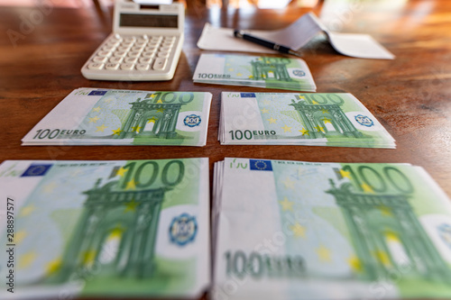 Soldi, assegni, calcolatrice, banconote da 100 euro per pagamenti e banche photo