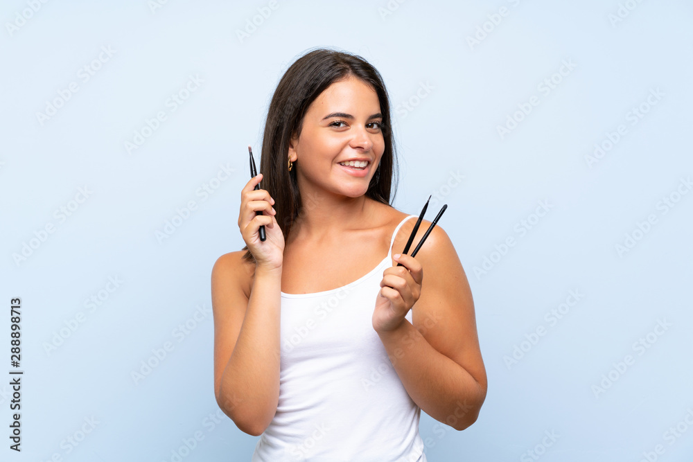 Young girl holding a lot of makeup brush Young girl holding a lot of makeup brush
