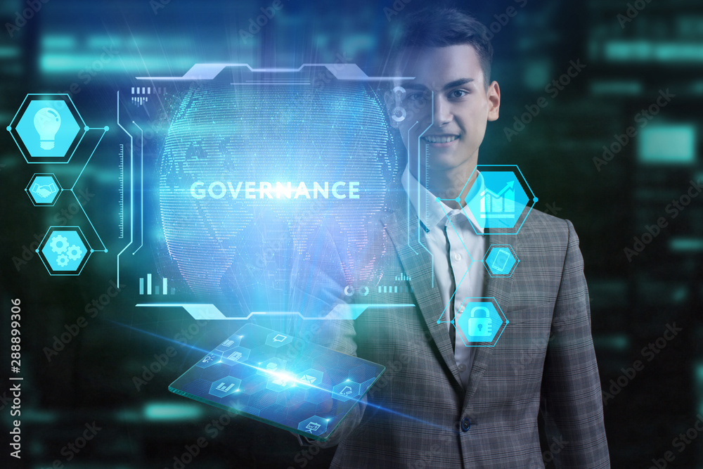 The concept of business, technology, the Internet and the network. A young entrepreneur working on a virtual screen of the future and sees the inscription: Governance The concept of business, technology, the Internet and the network. A young entrepreneur working on a virtual screen of the future and sees the inscription: Governance