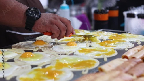 Male Chef Cooking Lots Eggs On A Large Hotplate sunny-side up photo