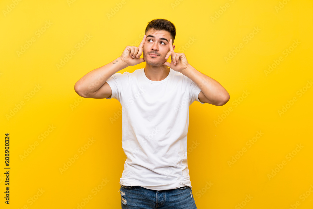 Young handsome man over isolated yellow background having doubts and thinking Young handsome man over isolated yellow background having doubts and thinking