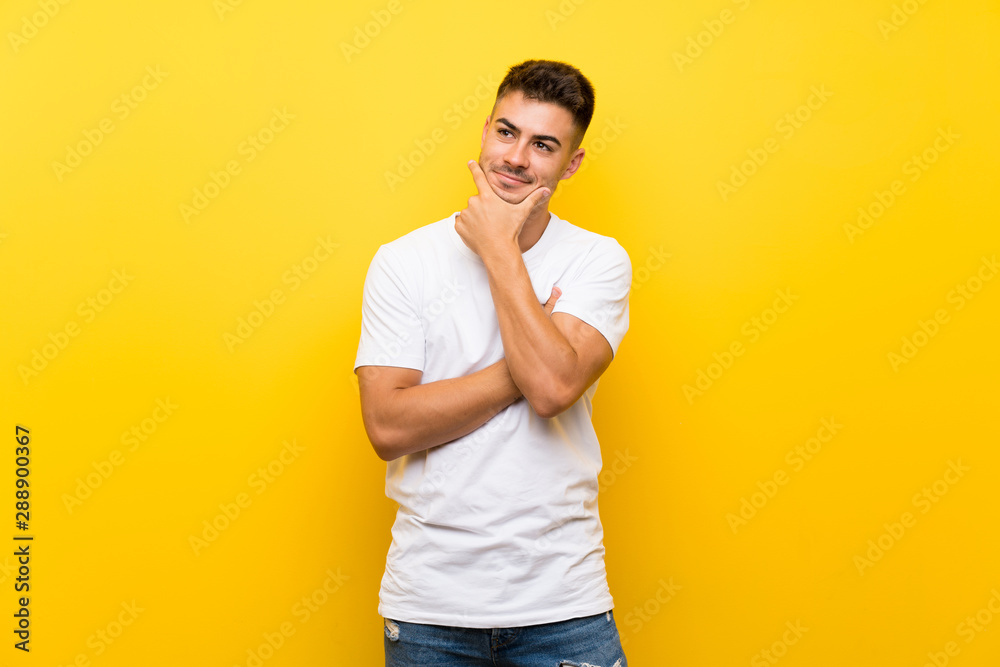 Young handsome man over isolated yellow background looking to the side Young handsome man over isolated yellow background looking to the side