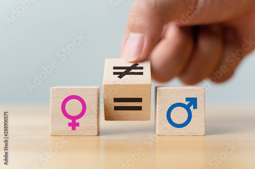 Concepts of gender equality. Hand flip wooden cube with symbol unequal change to equal sign photo