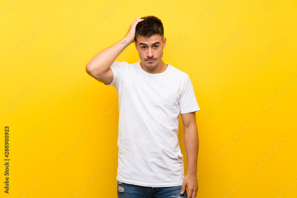 Young handsome man over isolated yellow background with an expression of frustration and not understanding Young handsome man over isolated yellow background with an expression of frustration and not understanding