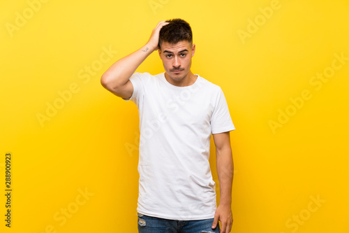 Young handsome man over isolated yellow background with an expression of frustration and not understanding