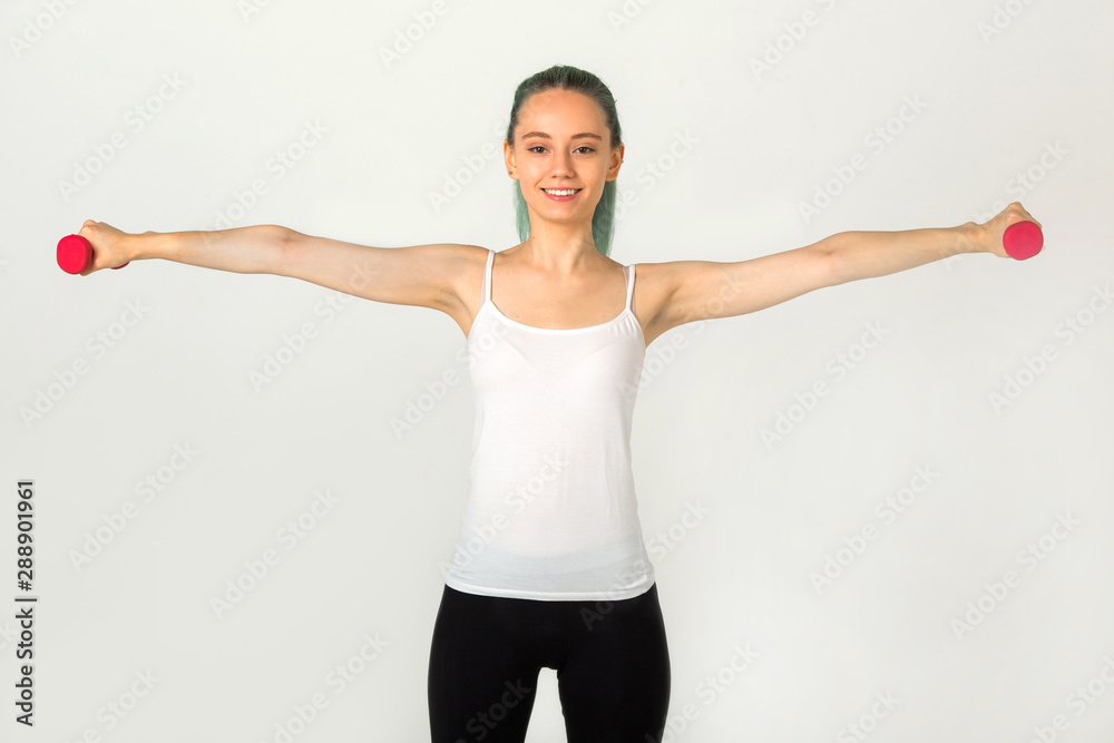 beautiful young woman in sportswear goes in for sports with dumbbells beautiful young woman in sportswear goes in for sports with dumbbells