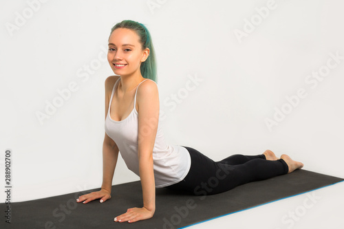 beautiful young woman doing gymnastics on a white background