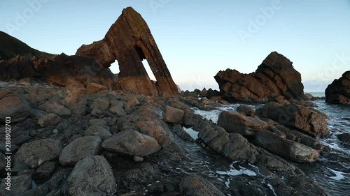 view of blackchurch rock formation and the rugged coastline at mouthmill beach, north devon with gentle waves photo