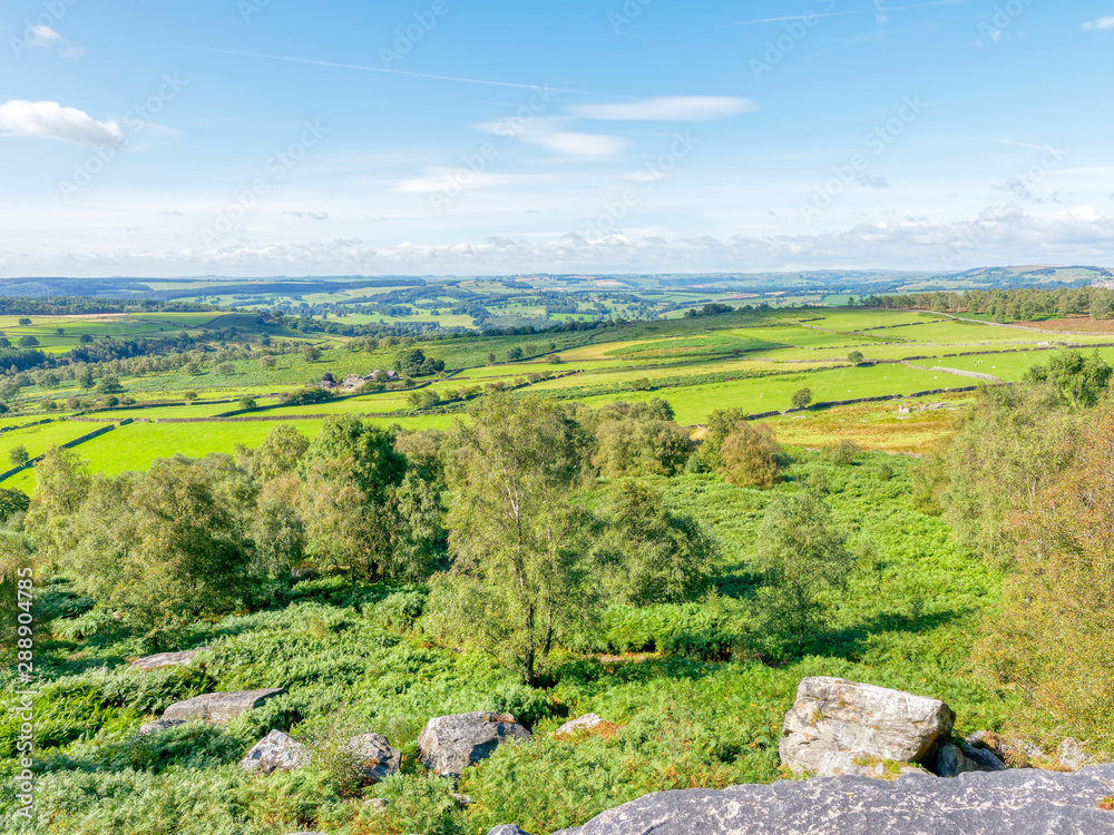 Obraz premium The Derbyshire countryside from high on Birchen Edge, a gritstone escarpment, on a bright summer day.