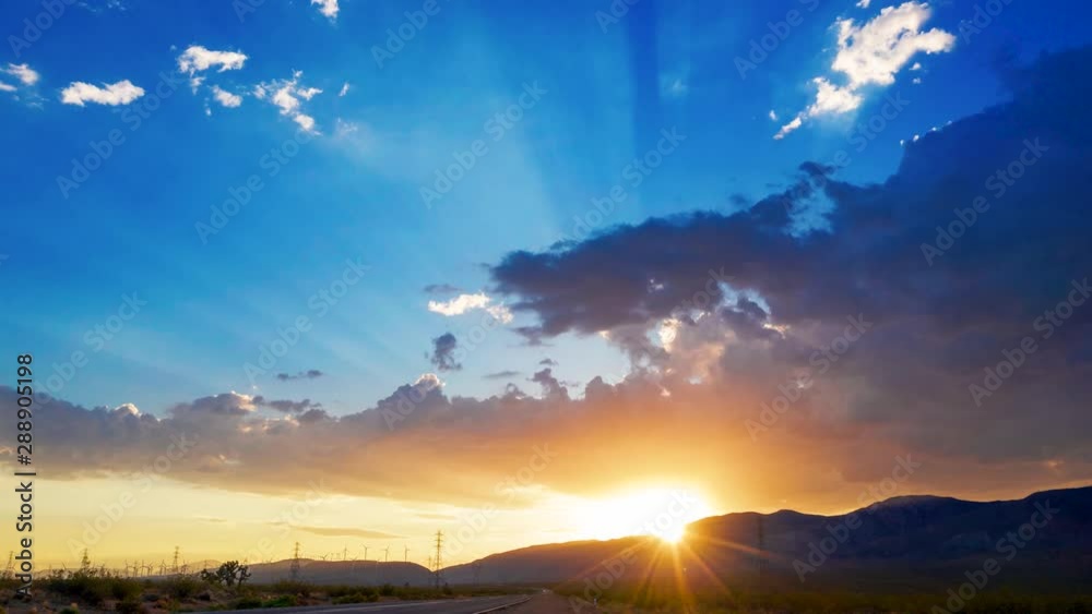 Spectacular golden blue sunset shining through clouds by Mojave Desert highway Spectacular golden blue sunset shining through clouds by Mojave Desert highway