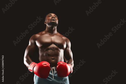 Concentrated black boxer preparing himself for fight