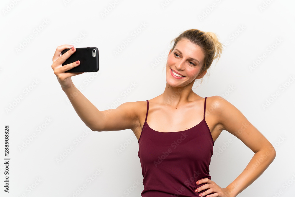 lYoung blonde woman using mobile phone and making a selfie lYoung blonde woman using mobile phone and making a selfie
