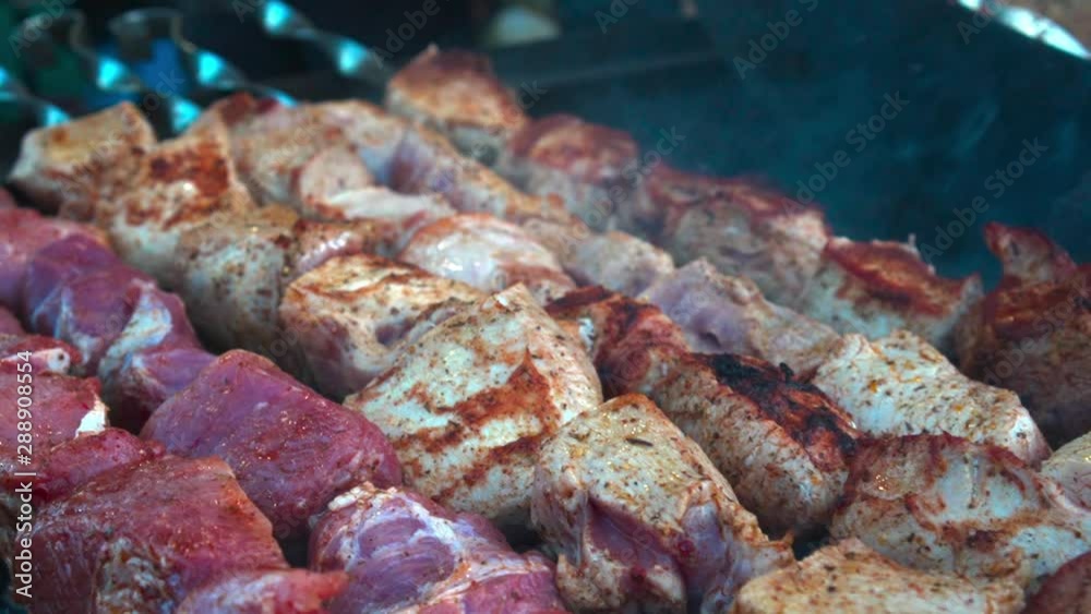 closeup of some meat skewers being grilled in a barbecue closeup of some meat skewers being grilled in a barbecue