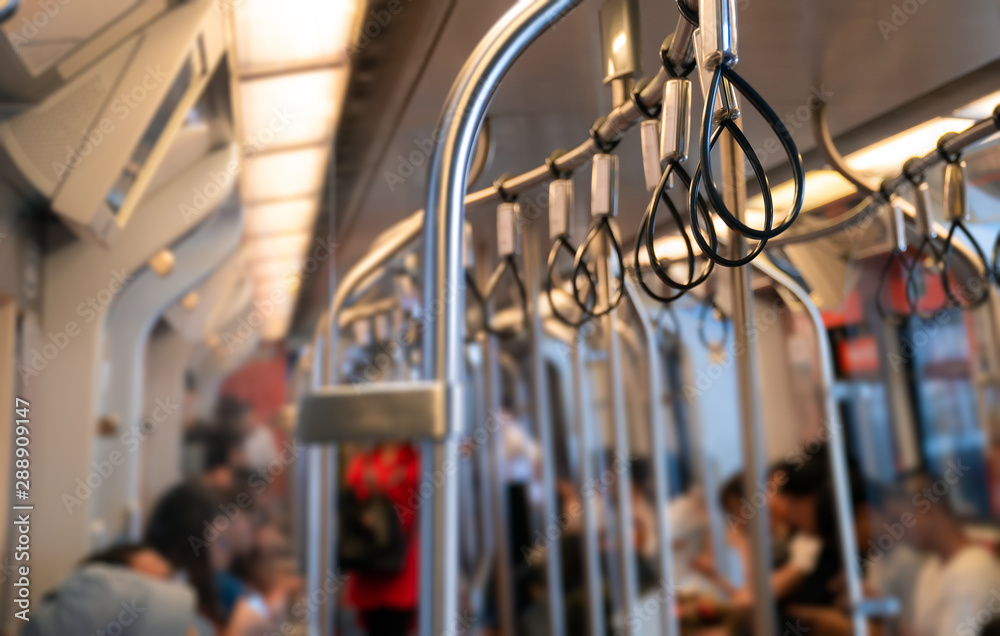 Low light and blurred view background. Empty handrail with many people in the sky train. Which is popular for quick and easy travel.