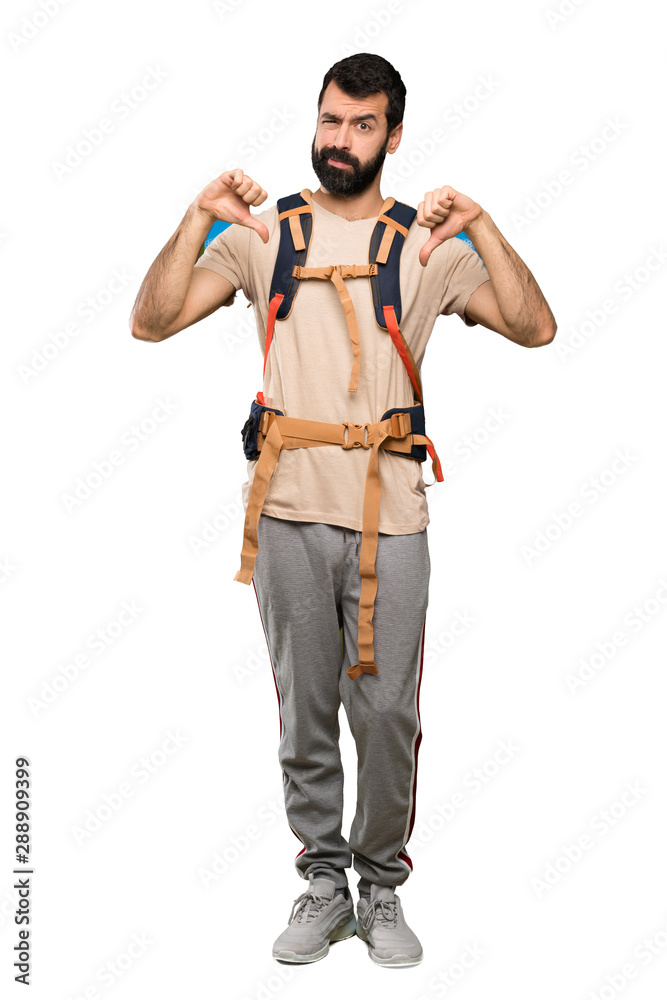 Hiker man showing thumb down over isolated white background Hiker man showing thumb down over isolated white background