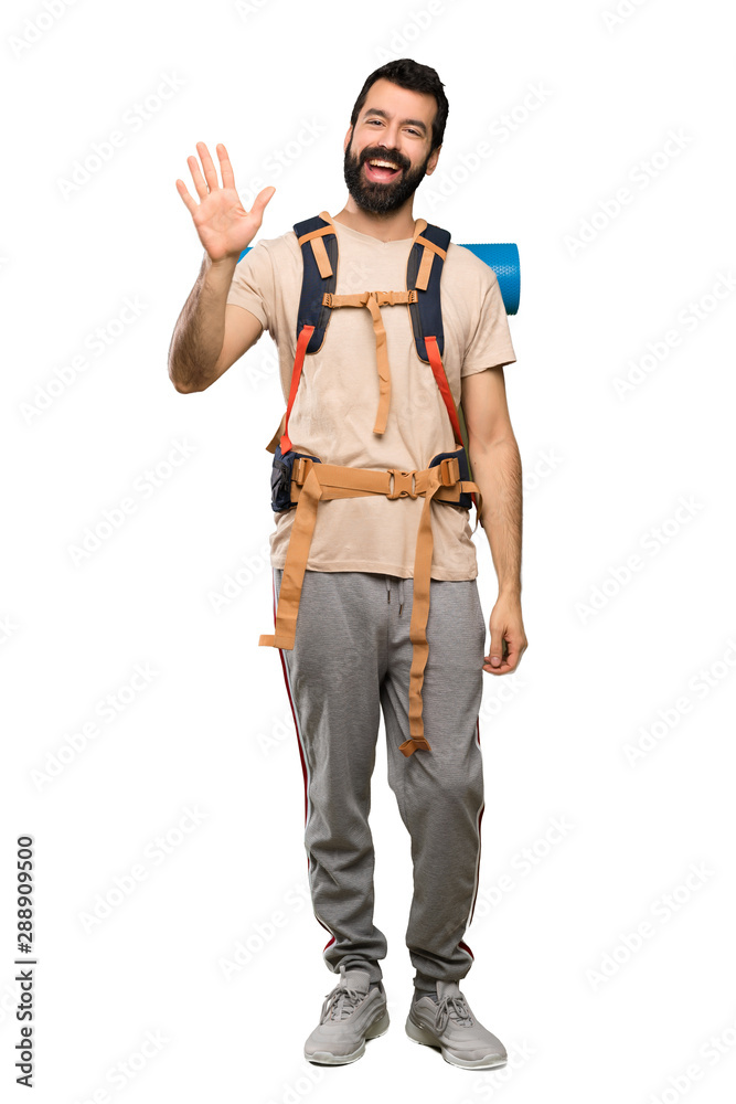 Hiker man saluting with hand with happy expression over isolated white background Hiker man saluting with hand with happy expression over isolated white background